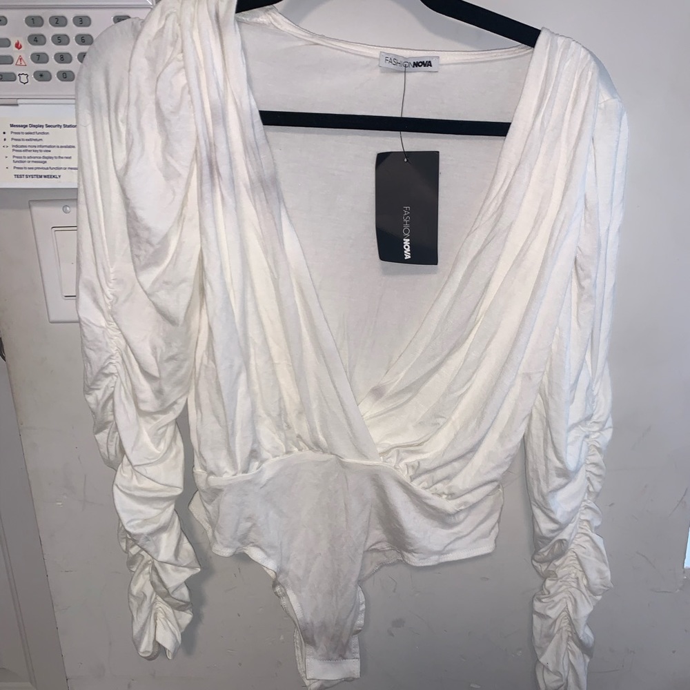 White ruched sleeve bodysuit. Low cut center. Snaps.
